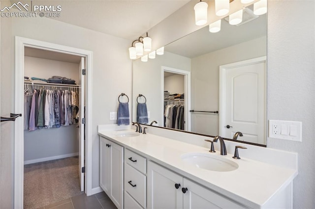 10671 Larimar Pt, Colorado Springs, CO 80905 - full bath featuring double vanity, a spacious closet, tile patterned flooring, and baseboards