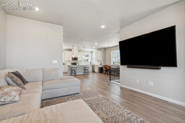 10671 Larimar Pt, Colorado Springs, CO 80905 - living room with light wood-style floors, baseboards, and recessed lighting