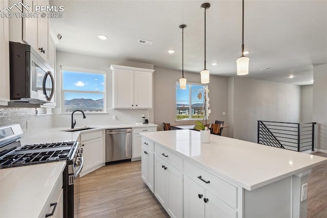 10671 Larimar Pt, Colorado Springs, CO 80905 - kitchen featuring stainless steel appliances, a sink, light wood-type flooring, a center island, and recessed lighting