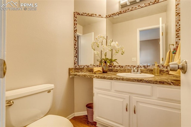 14915 Gleneagle Dr, Colorado Springs, CO 80921 - bathroom with toilet, wood finished floors, baseboards, and vanity