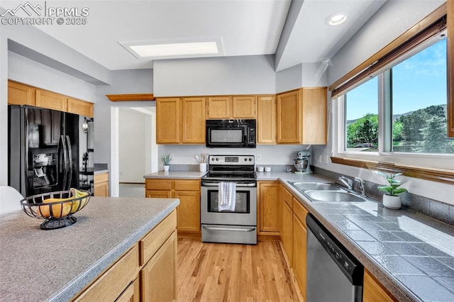 6390 Moccasin Pass Ct, Colorado Springs, CO 80919 - kitchen with black appliances, a sink, and light wood-style flooring