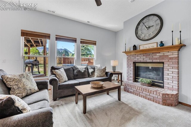 6390 Moccasin Pass Ct, Colorado Springs, CO 80919 - carpeted living room featuring a brick fireplace, ceiling fan, and a textured ceiling