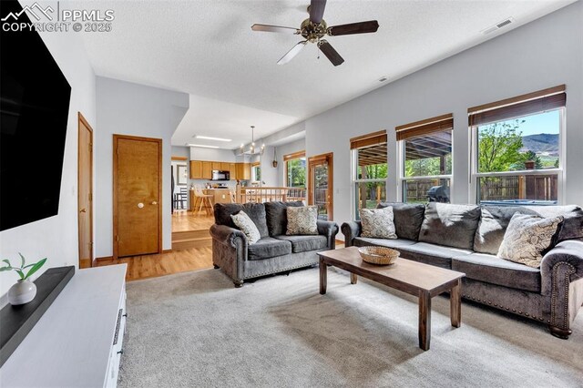 6390 Moccasin Pass Ct, Colorado Springs, CO 80919 - living room featuring light colored carpet, ceiling fan, and a chandelier