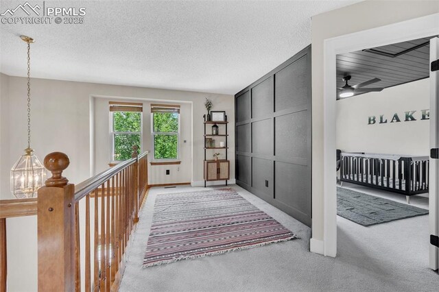 6390 Moccasin Pass Ct, Colorado Springs, CO 80919 - hallway with carpet flooring, a textured ceiling, and baseboards