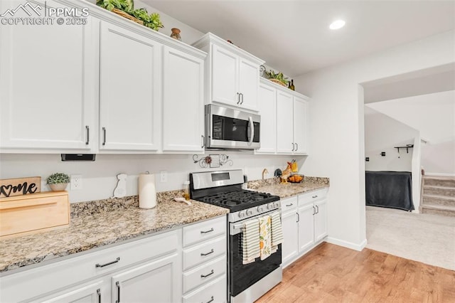 10140 Seawolf Dr, Colorado Springs, CO 80925 - kitchen with appliances with stainless steel finishes, light wood-style floors, white cabinetry, light stone countertops, and recessed lighting