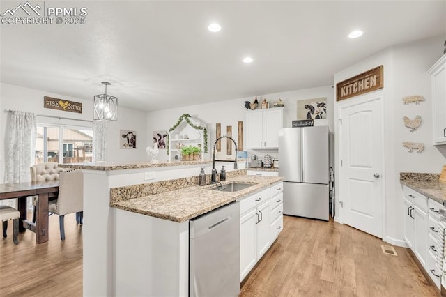 10140 Seawolf Dr, Colorado Springs, CO 80925 - kitchen with appliances with stainless steel finishes, a sink, white cabinets, light wood-style floors, and recessed lighting