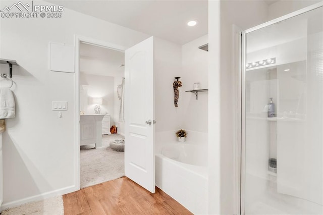 10140 Seawolf Dr, Colorado Springs, CO 80925 - full bath with a bath, a shower stall, wood finished floors, and recessed lighting