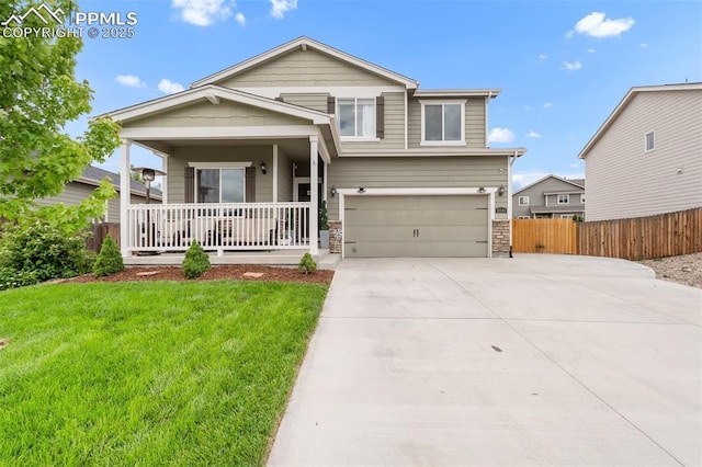 10140 Seawolf Dr, Colorado Springs, CO 80925 - view of front of home featuring a porch, driveway, a garage, and stone siding