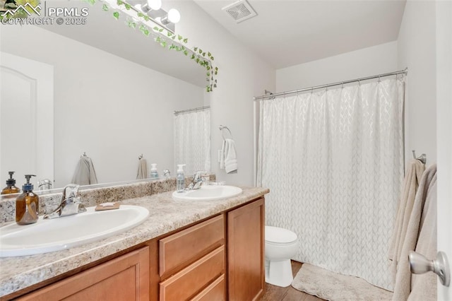10140 Seawolf Dr, Colorado Springs, CO 80925 - full bath featuring double vanity, toilet, wood finished floors, and curtained shower