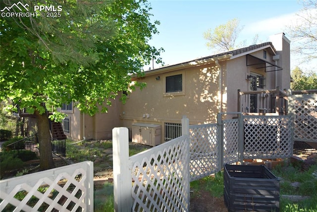 rear view of property featuring stucco siding