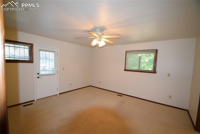 spare room featuring ceiling fan, baseboards, and light colored carpet