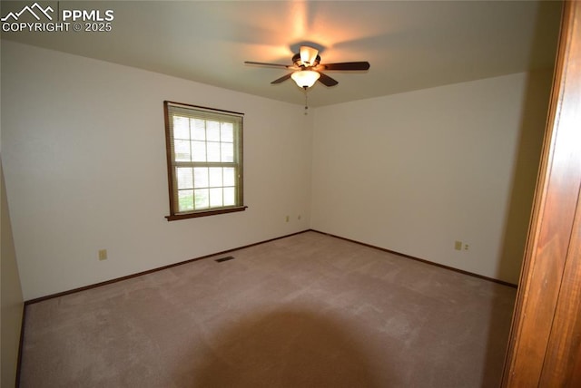 unfurnished room with ceiling fan, light colored carpet, and baseboards