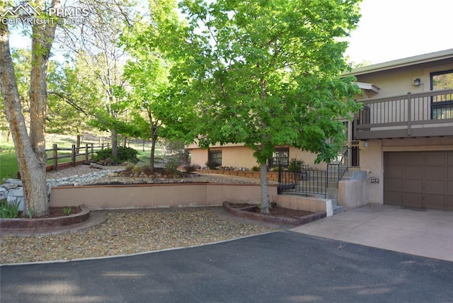 view of front of property with stucco siding, driveway, and a garage