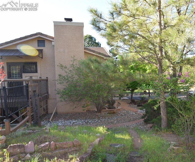 view of home's exterior with a chimney and stucco siding