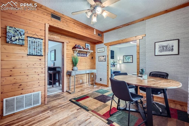 738 E Cache La Poudre St, Colorado Springs, CO 80903 - dining area with ceiling fan, wood finished floors, wooden walls, a textured ceiling, and baseboards