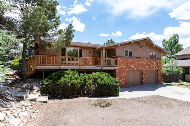 6331 Mesedge Dr, Colorado Springs, CO 80919 - view of front of home with driveway, brick siding, a garage, and a wooden deck