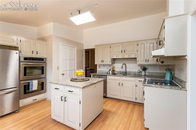 6331 Mesedge Dr, Colorado Springs, CO 80919 - kitchen with appliances with stainless steel finishes, a sink, tasteful backsplash, and light wood-style flooring