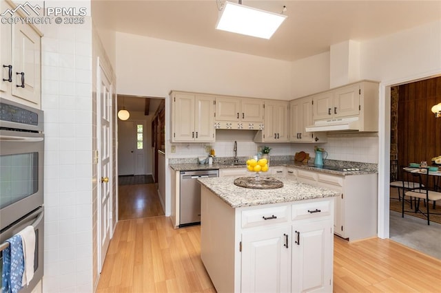 6331 Mesedge Dr, Colorado Springs, CO 80919 - kitchen featuring appliances with stainless steel finishes, light wood finished floors, a sink, and backsplash