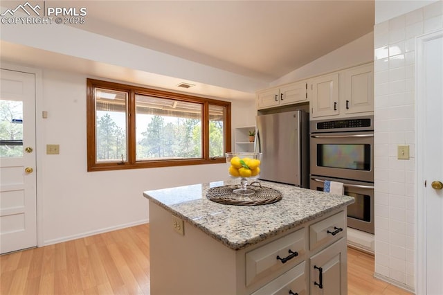 6331 Mesedge Dr, Colorado Springs, CO 80919 - kitchen with stainless steel appliances, light wood-type flooring, plenty of natural light, and vaulted ceiling