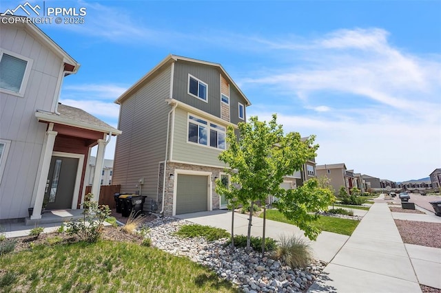 793 Grissom Dr, Colorado Springs, CO 80915 - view of front of property featuring an attached garage, stone siding, concrete driveway, and a residential view