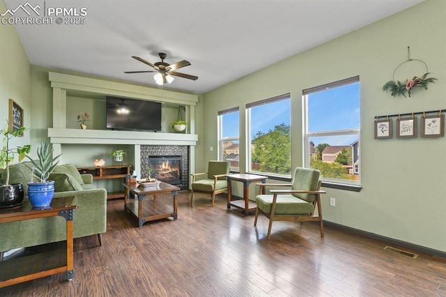 7534 Sistine Ln, Fountain, CO 80817 - living area with a glass covered fireplace, ceiling fan, wood finished floors, and baseboards
