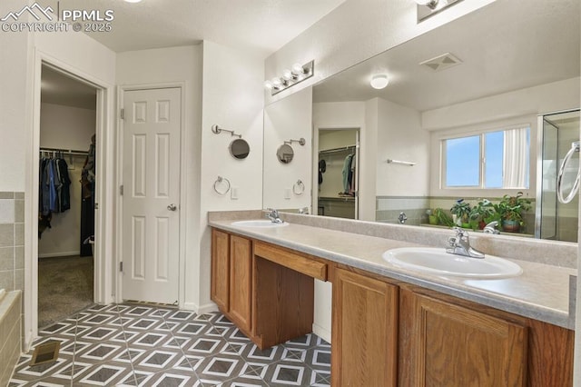7534 Sistine Ln, Fountain, CO 80817 - full bath featuring double vanity, a spacious closet, and a shower stall