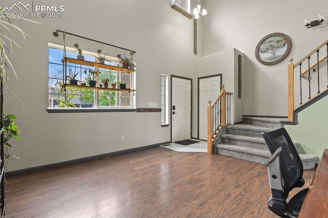 7534 Sistine Ln, Fountain, CO 80817 - entrance foyer featuring stairs, wood finished floors, a high ceiling, and baseboards
