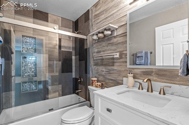 8020 Firecracker Trl, Fountain, CO 80817 - full bathroom with vanity, toilet, combined bath / shower with glass door, a textured ceiling, and wood walls
