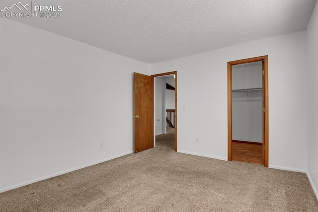 3300 W Florida Ave Unit 26, Denver, CO 80219 - unfurnished bedroom featuring carpet, baseboards, a spacious closet, a textured ceiling, and a closet