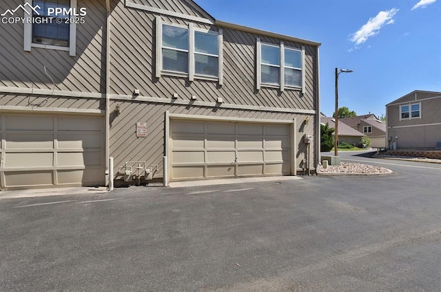3300 W Florida Ave Unit 26, Denver, CO 80219 - view of front of house with an attached garage and asphalt driveway