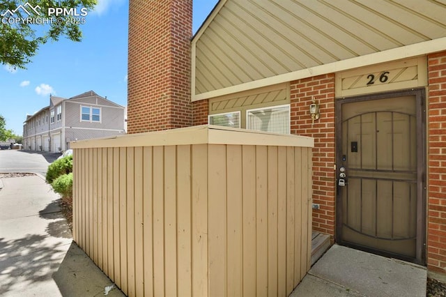 3300 W Florida Ave Unit 26, Denver, CO 80219 - property entrance featuring brick siding, elevator, and a chimney
