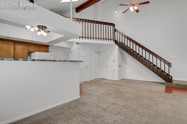 3300 W Florida Ave Unit 26, Denver, CO 80219 - unfurnished living room with a ceiling fan, high vaulted ceiling, stairway, carpet floors, and baseboards