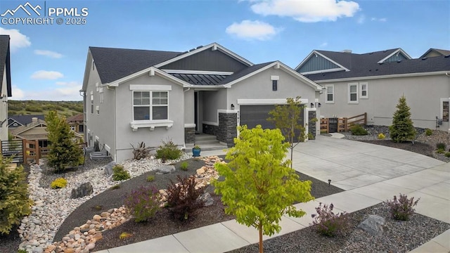 2267 Merlot Dr, Colorado Springs, CO 80921 - view of front of home with concrete driveway, a standing seam roof, stucco siding, a garage, and metal roof