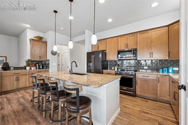 2267 Merlot Dr, Colorado Springs, CO 80921 - kitchen featuring stainless steel appliances, a sink, tasteful backsplash, brown cabinetry, and recessed lighting