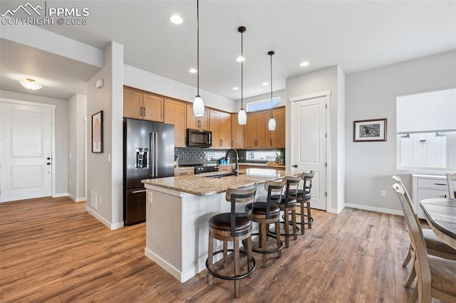 2267 Merlot Dr, Colorado Springs, CO 80921 - kitchen with black appliances, a sink, wood finished floors, backsplash, and recessed lighting