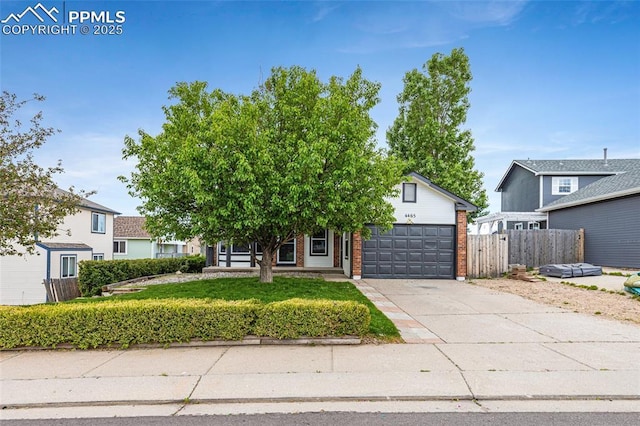 4465 Archwood Dr, Colorado Springs, CO 80920 - obstructed view of property featuring an attached garage, concrete driveway, and brick siding
