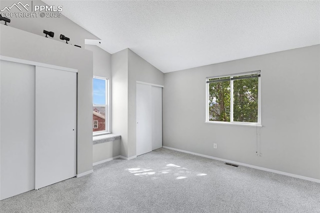 4465 Archwood Dr, Colorado Springs, CO 80920 - unfurnished bedroom with two closets, vaulted ceiling, carpet flooring, a textured ceiling, and baseboards