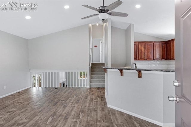 4465 Archwood Dr, Colorado Springs, CO 80920 - kitchen with a kitchen bar, ceiling fan, lofted ceiling, wood finished floors, and baseboards