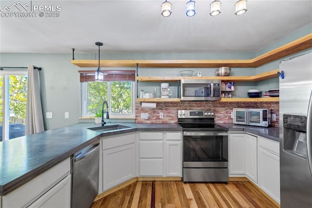 2620 Warrenton Way, Colorado Springs, CO 80922 - kitchen featuring stainless steel appliances, a sink, open shelves, and healthy amount of natural light