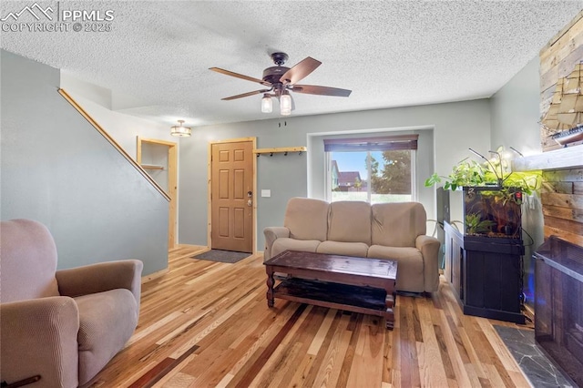 2620 Warrenton Way, Colorado Springs, CO 80922 - living area with wood finished floors, a fireplace, a textured ceiling, and a ceiling fan