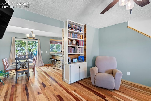 2620 Warrenton Way, Colorado Springs, CO 80922 - living area with light wood-style floors, a ceiling fan, and a textured ceiling