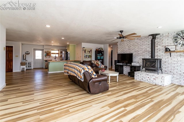 7815 Mallard Dr, Peyton, CO 80831 - living room featuring wood finished floors, a wood stove, ceiling fan, baseboards, and recessed lighting