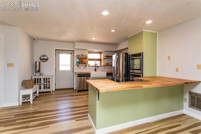 7815 Mallard Dr, Peyton, CO 80831 - kitchen with butcher block counters, stainless steel appliances, light wood-style flooring, a sink, and a peninsula