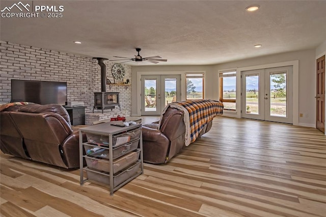 7815 Mallard Dr, Peyton, CO 80831 - living area featuring french doors, a wood stove, light wood-type flooring, recessed lighting, and ceiling fan