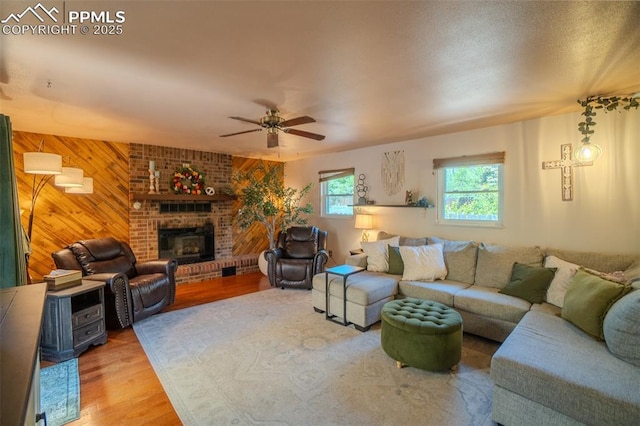 4580 N Sleepy Hollow Cir, Colorado Springs, CO 80917 - living area featuring a ceiling fan, wood finished floors, wooden walls, and a fireplace