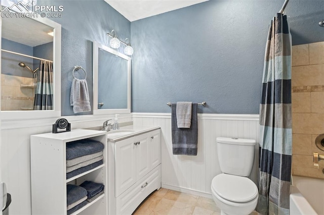 7350 Devinney Ct, Arvada, CO 80005 - bathroom with vanity, a wainscoted wall, shower / bath combo with shower curtain, and toilet