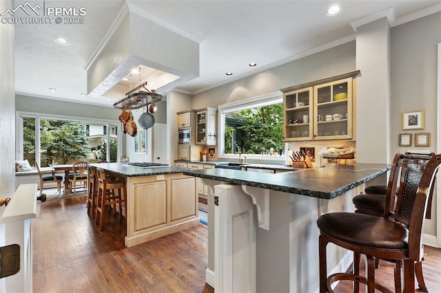 6 3rd St, Colorado Springs, CO 80906 - kitchen with a breakfast bar area, dark countertops, wood finished floors, recessed lighting, and crown molding