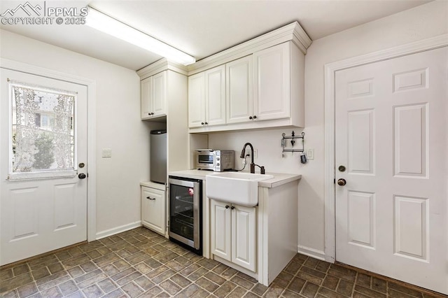 6 3rd St, Colorado Springs, CO 80906 - laundry area with wine cooler, baseboards, a sink, and brick patterned floors