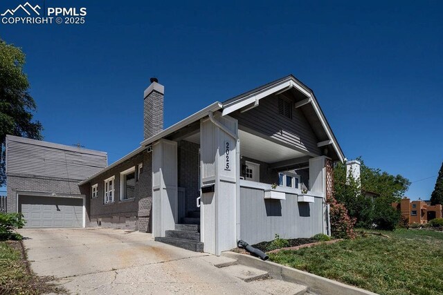 2025 W St, Pueblo, CO 81003 - view of home's exterior with a chimney, driveway, and an attached garage