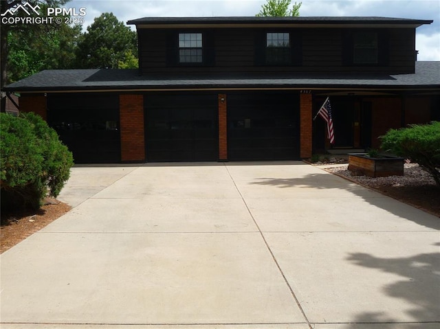 4307 Valli Vista Rd, Colorado Springs, CO 80915 - view of front of property with an attached garage, driveway, and brick siding